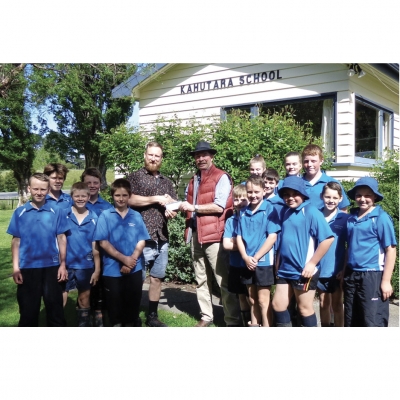 Kahutara project: Ross Cottle (DUNZ chair) left, presents a cheque to Hamish McRae on behalf of Ducks Unlimited NZ to assist in developing the Kahutara School Wetlands project. Ross and Hamish are accompanied by senior pupils from Kahutara School.